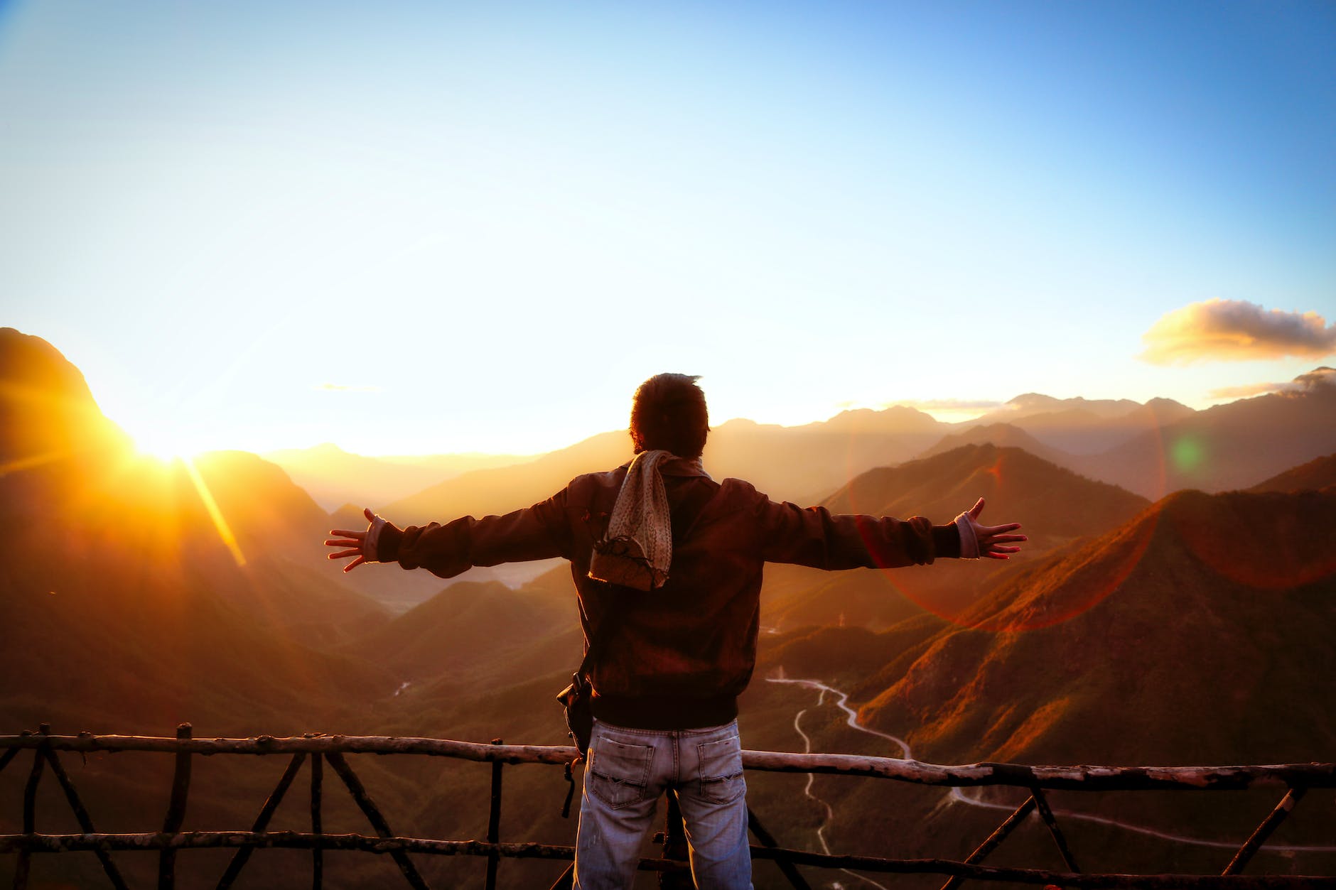 man in black jacket standing near sunset